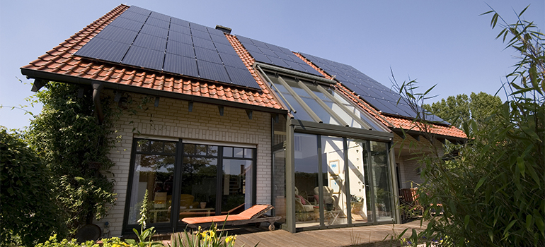 Rückseite eines Wohnhauses mit Solaranlage, Wintergarten und Terrasse